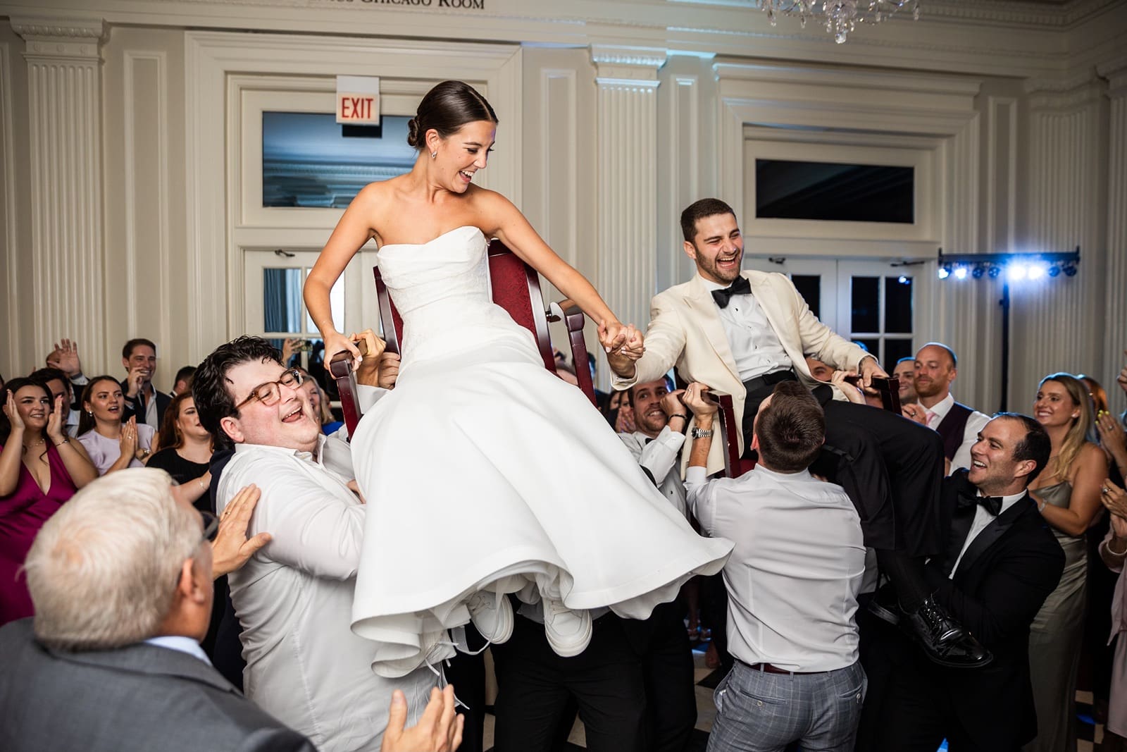 Bride and groom are lifted into chairs at the Chicago History Museum wedding reception