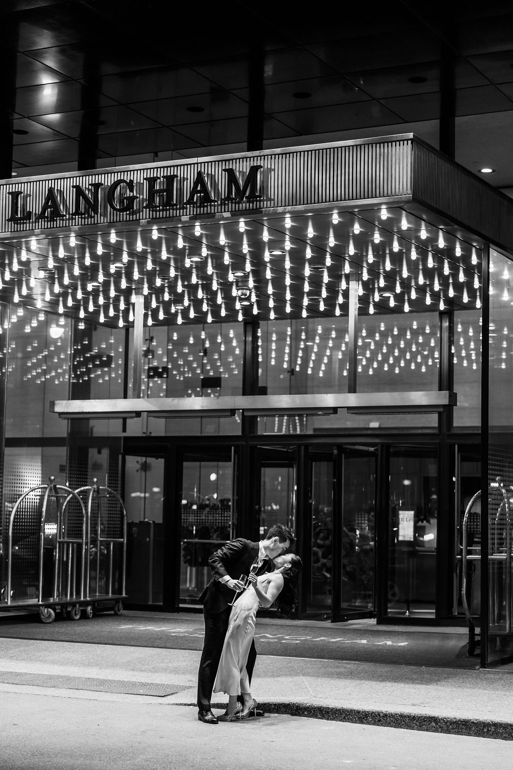 Bride and groom kiss outside of the Langham Chicago