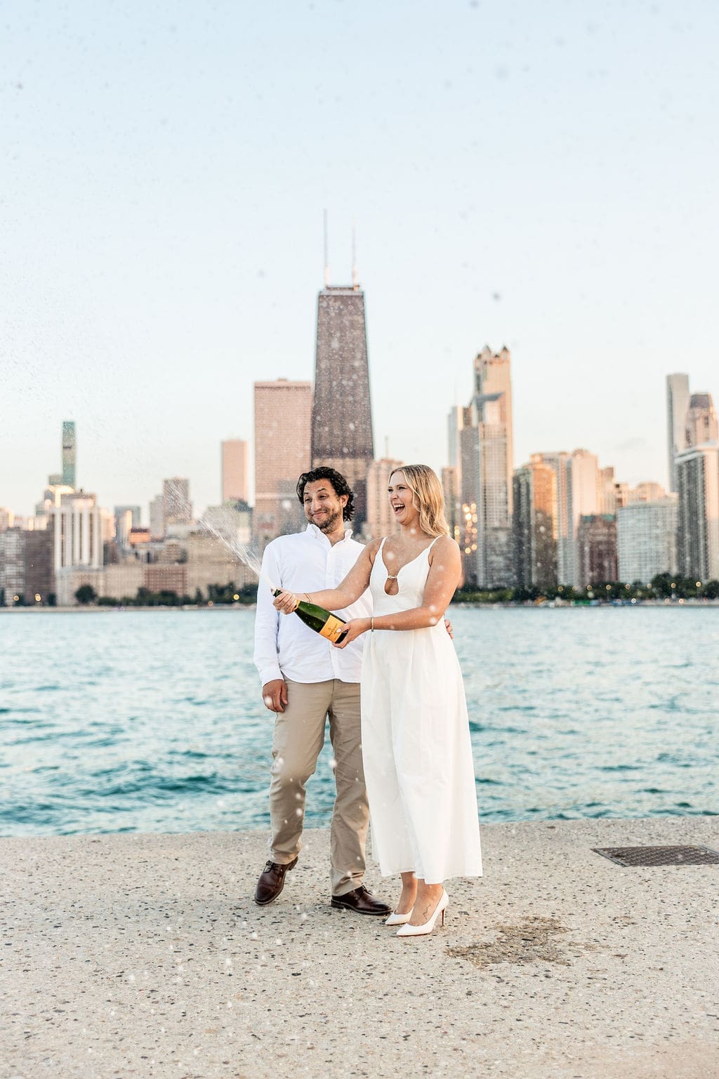 Couple pops champagne at their North Avenue Beach engagement photos