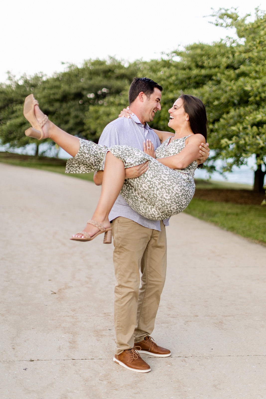 Man lifts woman during their Chicago engagement photos at North Avenue Beach